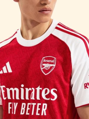 Arsenal 2025-26 jersey modeled in front of Emirates Stadium