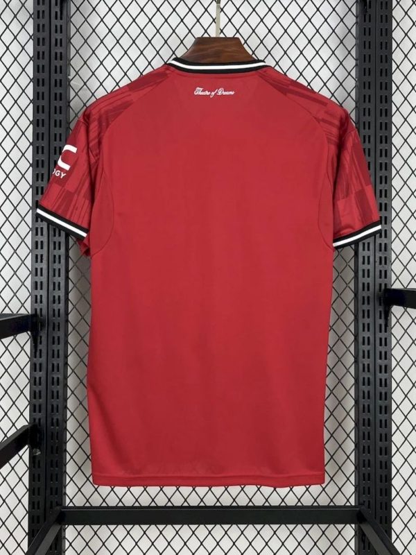 Close-up of the Manchester United 25/26 jersey with stitched crest and sponsor